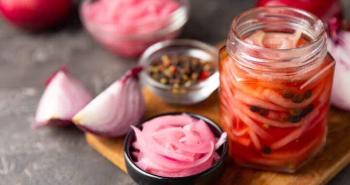 Cebollas moradas encurtidas en un frasco de vidrio con vinagre de manzana