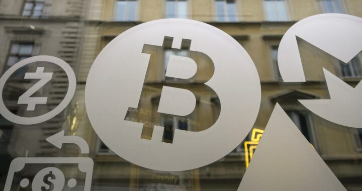 Imagen de un hacker en una pantalla de computadora con un fondo de criptomonedas