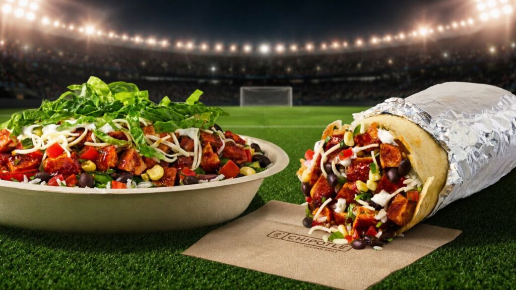 Una persona con una camiseta de fútbol sosteniendo un plato de comida de Chipotle con una sonrisa de satisfacción