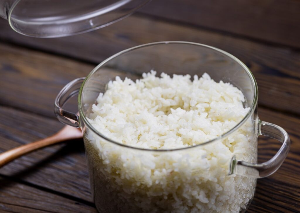 Un plato de arroz blanco suelto y brillante, decorado con hierbas frescas