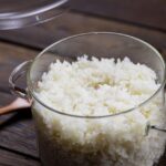 Un plato de arroz blanco suelto y brillante, decorado con hierbas frescas