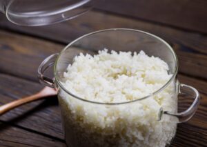 Un plato de arroz blanco suelto y brillante, decorado con hierbas frescas