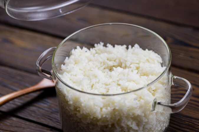 Un plato de arroz blanco suelto y brillante, decorado con hierbas frescas