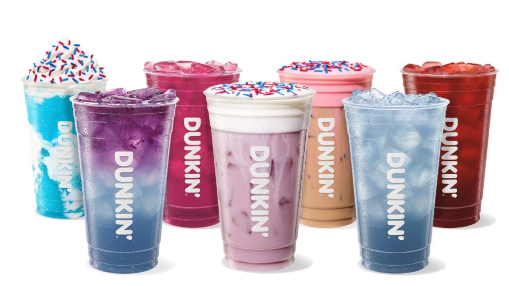 Una persona sosteniendo una taza de Dunkin' con decoraciones de águila en un vaso de vidrio tridimensional en forma de águila