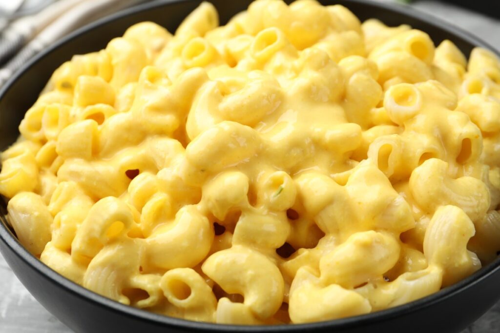 Imagen de macarrones con queso y salsa Alfredo en un plato, con un aviso de retiro en el fondo
