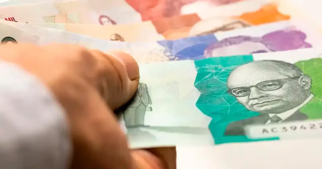 Imagen de una persona ahorrando dinero en un banco, con un gráfico de economía al fondo que muestra la absorción del ahorro por el Gobierno