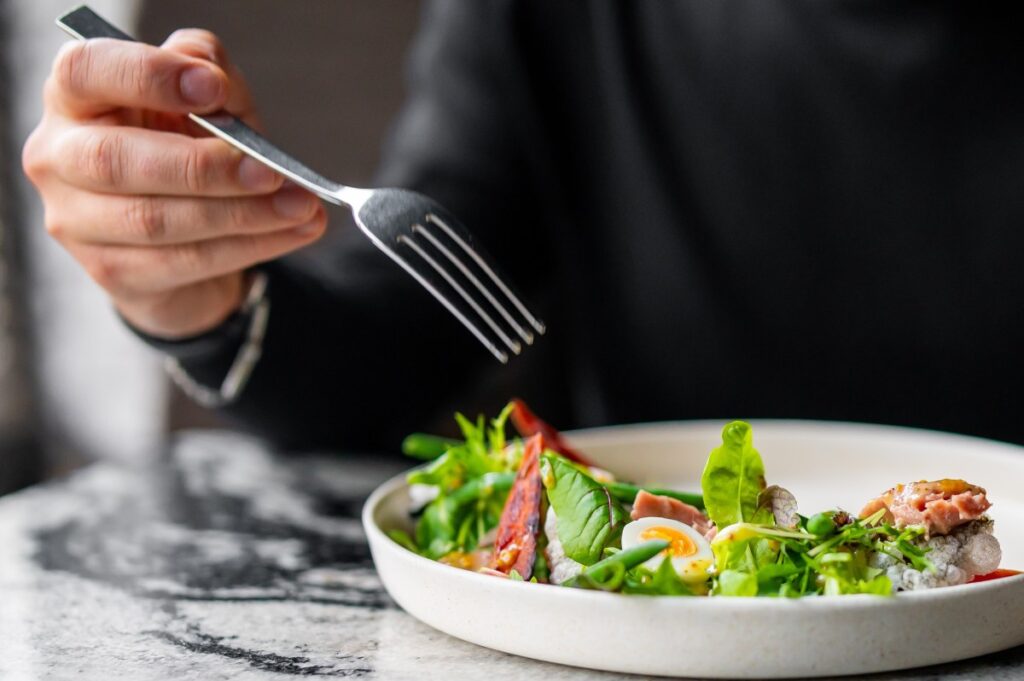Una deliciosa ensalada de lechuga, aguacate, pepino y atún, lista para ser disfrutada.