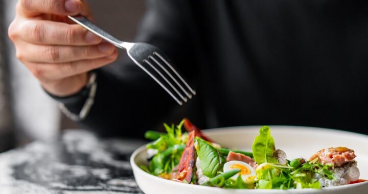 Una deliciosa ensalada de lechuga, aguacate, pepino y atún, lista para ser disfrutada.