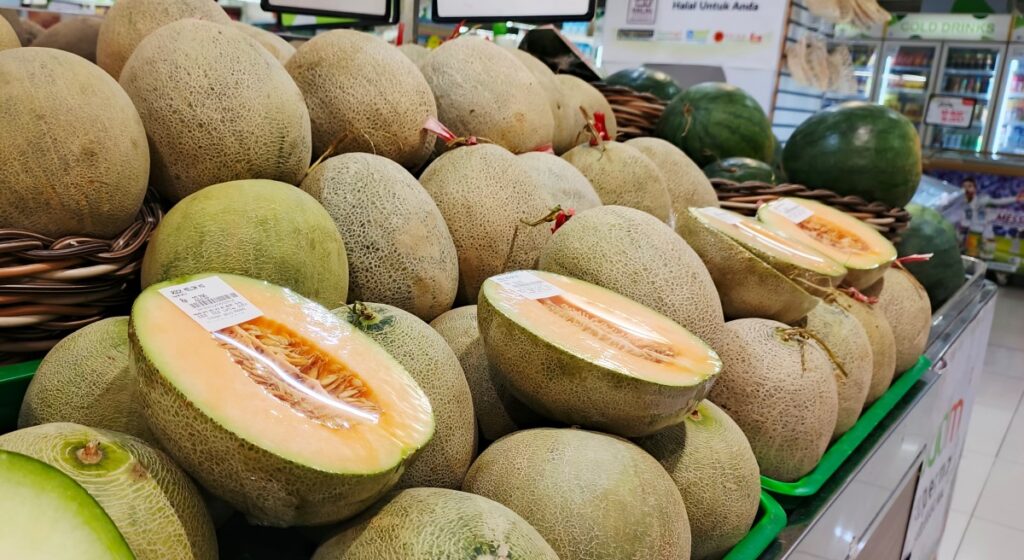 Un melón cantalupo fresco y jugoso sobre una mesa de madera 'de cama' con una mancha amarilla en la parte inferior