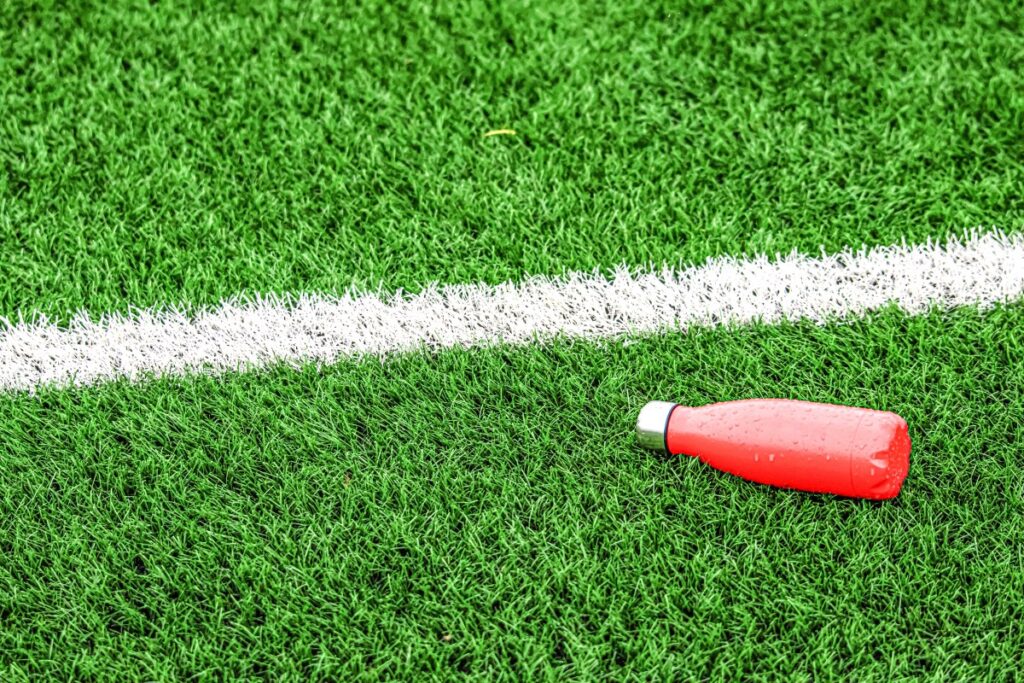 Persona bebiendo agua de coco en un estadio de fútbol