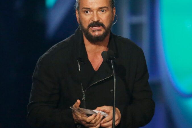 Ricardo Arjona y Javi Flores cantando juntos en un escenario