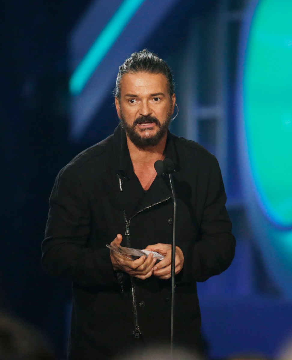 Ricardo Arjona y Javi Flores cantando juntos en un escenario