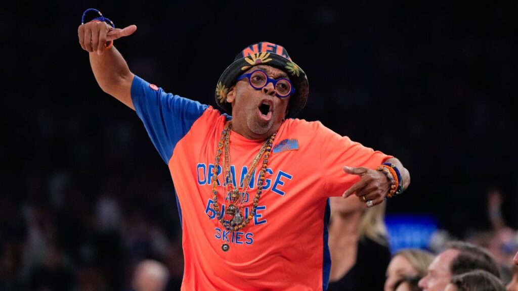 Spike Lee sonriendo en una calle cerrada de Nueva York llena de gente celebrando con camisetas de los Knicks