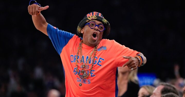 Spike Lee sonriendo en una calle cerrada de Nueva York llena de gente celebrando con camisetas de los Knicks