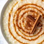 tazón de arroz con leche cremoso con canela en rama