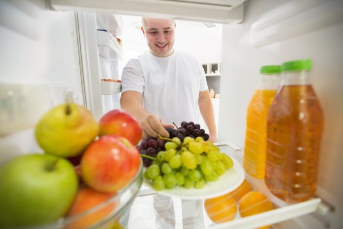 Una persona sosteniendo una fruta en la mano mientras se prepara para dormir