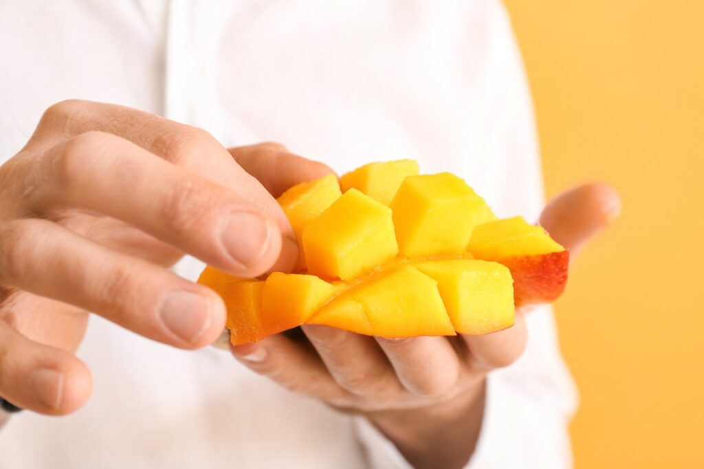 Una deliciosa porción de mango fresco sobre una tabla de madera, con un fondo de noche