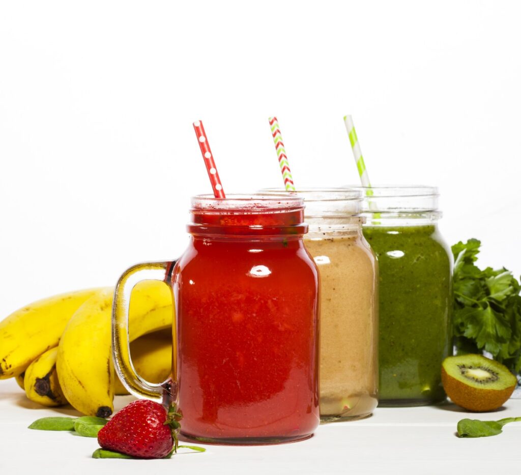 Una mujer disfrutando de un licuado verde de manzana, pepino y espinacas